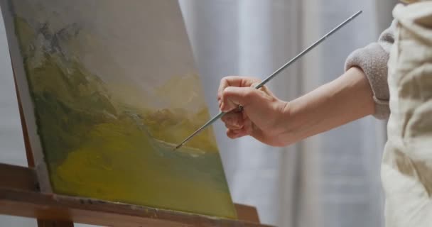 Młoda kobieta spędza czas na wieczornym rysowaniu pejzażu na płótnie, używając pędzli i farb olejnych — Wideo stockowe