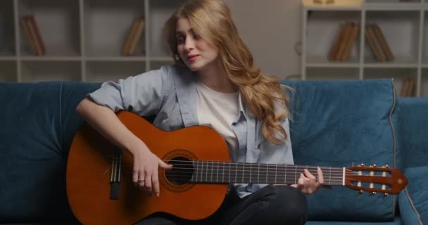 Música fan mujer está jugando guitarra descansando solo en casa por la noche, medio retrato de feliz sonriente dama — Vídeo de stock