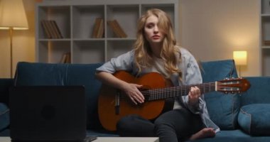 Kendini tecrit ve tecrit süresince akşam ev eğlencesi, kadın gitar ile müzik çalıyor, orta boy oturma odasında portre.