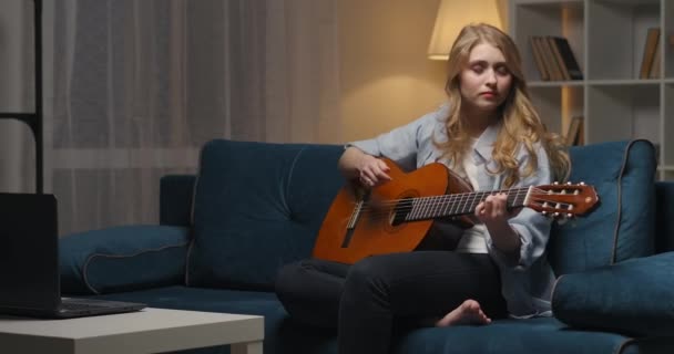 Getalenteerde geïnspireerde vrouw speelt gitaar thuis 's avonds, genieten van favoriete deuntje, muziek maken — Stockvideo