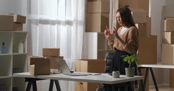 Chat en línea y reunión informativa con los empleados y socios, mujer de negocios se está comunicando desde su almacén por computadora portátil, retrato medio — Vídeos de Stock