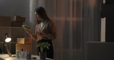 El yapımı kozmetik dükkanının kadın sahibi geceleri evde çalışıyor, yeni ürünler okuyor, not defterine bilgi dolduruyor