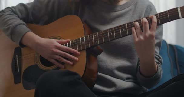 Het meisje probeert gitaar te spelen. Close-up opname. — Stockvideo
