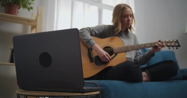 그 소녀는 줄을 따라 오른손 손가락을 여러 번 움직 인다. 한 젊은 음악가가 클래식 기타 연주를 배우고 있다. 중간 샷에서 확대 카메라 확대 — 비디오