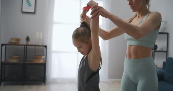 Antrenorul feminin controlează antrenamentul sportiv al fetiței, ajutând la exerciții fizice, mamă și fiică — Videoclip de stoc