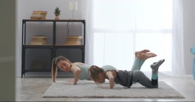 Anne ve küçük kızın evde fitness eğitimi, sabah antrenmanı ve sağlıklı yaşam tarzı.