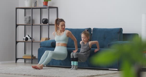 早上进行家庭训练，母亲和女儿在做体育锻炼，从沙发上站起来 — 图库视频影像