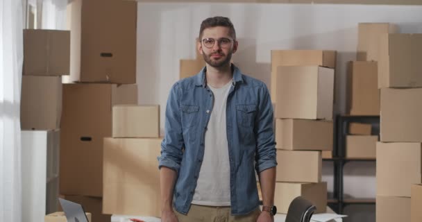 Handsome young small business owner smiles and folded his arms. medium shot — Stock Video