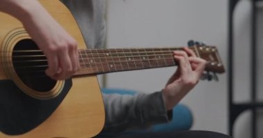 Gençler akustik gitarda yeni akorlar öğreniyor. Yakın çekim..