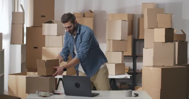Two men carry cardboard boxes with goods indoors — Stock Video