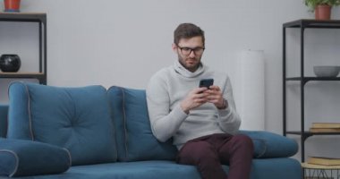 içe dönük, akıllı telefon kullanarak, internette sörf yaparak, oturma odasında kanepede yalnız başına oturarak, hafta sonunu evde geçiriyor.
