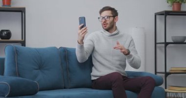 Adam kendi kendine video çekiyor ya da sosyal ağda ya da blogda canlı yayın yapıyor, evde oturuyor, akıllı telefon kullanıyor.