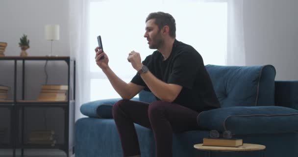 Homem adulto está assistindo jogo de esportes on-line por smartphone, tradução da internet de atividades esportivas — Vídeo de Stock