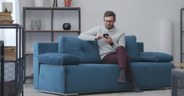 Ενήλικας άνθρωπος διαβάζει το μήνυμα στο smartphone και χαίρεται με τη νίκη λαχείο ή καλά νέα, άλμα στο σαλόνι — Αρχείο Βίντεο