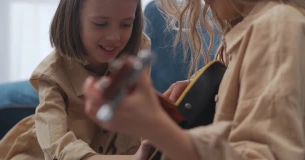 4.看到妈妈弹吉他的样子，看到孩子笑的样子，开心的小女孩哈哈大笑 — 图库视频影像