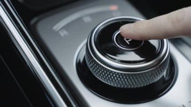 Yakından bakan adam otomatik vites kutusunun şanzımanını değiştiriyor. Park, sürüş, geri vites. Erkek sürücünün yakın çekimi otomatik vites kolunu park yerinden sürücü koltuğuna çevirir.