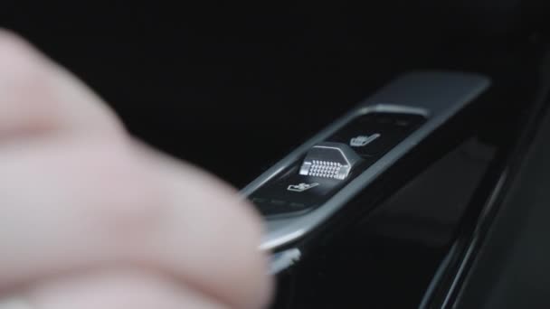 Primer plano del hombre presionando el botón en el panel del coche. Botón para calefacción de asientos en coche. el hombre enciende los asientos calefaccionados. — Vídeo de stock
