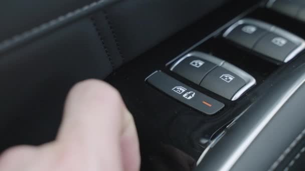 Dětské zamykání dveří stisknutím tlačítka na ovladači dveří řidiče. zámek proti náhodnému otevření dveří v bočním povrchu dveří v autě dětmi. — Stock video