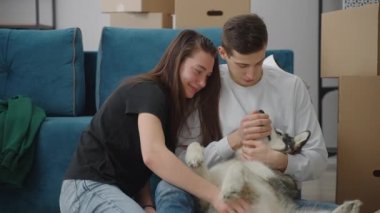 Neşeli bir kız köpeği okşar ve yüksek sesle güler..