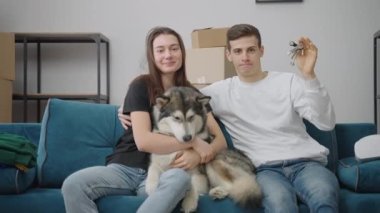Mutlu, genç bir aile ve bir köpek yeni bir dairede kanepede oturuyorlar. Neşeli bir adam elinde yeni bir evin anahtarlarını tutuyor. Mutlu kadın sevgili köpeğine sarılıyor..