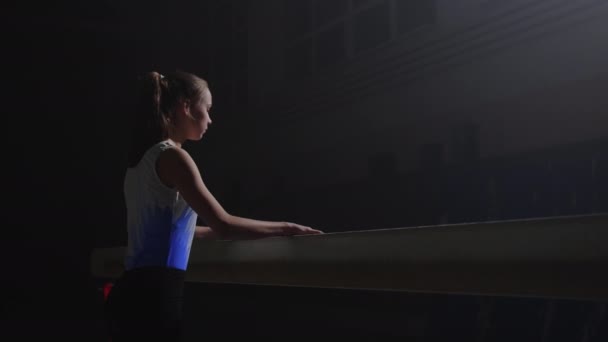 Mladý sportovec dívka je trénink sám na vyvážení paprsku ve sportovní hale, zpomalení záběr, sport a aktivita — Stock video