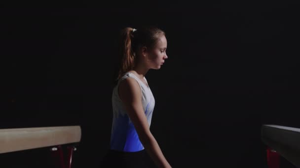 Junior vrouwelijke sportman, portret in gymzaal, tiener meisje draagt sportkleding loopt tussen evenwichtsbalk — Stockvideo