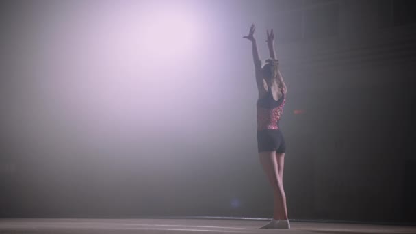 Юная гимнастка на соревнованиях, девочка-подросток готовится к выполнению упражнений на полу, вид сзади — стоковое видео