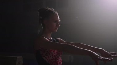 Kendine güvenen genç kız artistik jimnastik için mayo giyiyor ve yarışmaya hazırlanıyor.