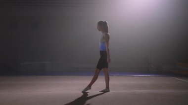Spor salonlarında, spor salonunda ve gençlerde, spor aktivitelerinde atkuyruklu bir kız takla atıyor.
