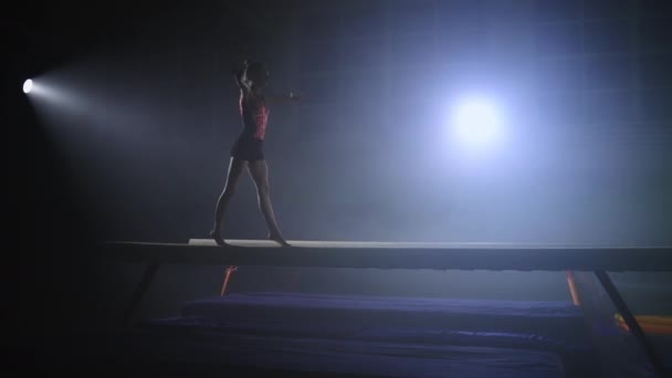 Training van jonge vrouwelijke turnster in sporthal, artistieke gymnastiek op balansbalk, voorbereiding op kampioenschap, slow motion — Stockvideo