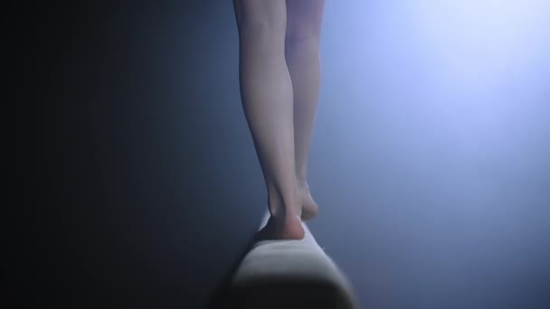 Vrouwelijke turner op balansbalk, close-up van de benen, stappen doen en springen, balans houden, achteraanzicht — Stockvideo