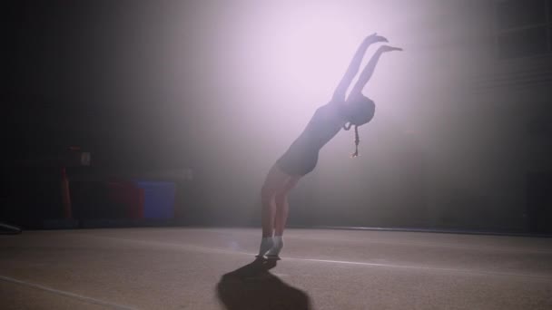 Спортивна дівчина-підліток робить два невдахи назад на весняному поверсі, тренування тільки в гімнастичному залі, художня гімнастика — стокове відео