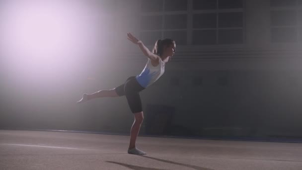 Junior gimnasta femenina está realizando pose en una pierna en el suelo, entrenamiento deportivo de la adolescente, preparándose para la competencia — Vídeos de Stock