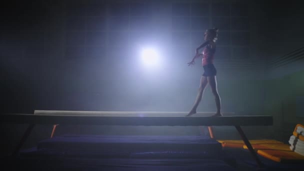 Sportig tonåring flicka repeterar sitt program för tävling av konstnärlig gymnastik på balans balk — Stockvideo
