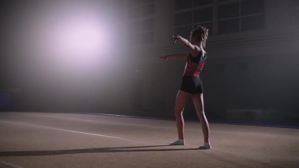 Adolescent vrouwelijke turner poseert op de vloer, training in gymnastische hal, kampioenschap van artistieke gymnastiek — Stockvideo