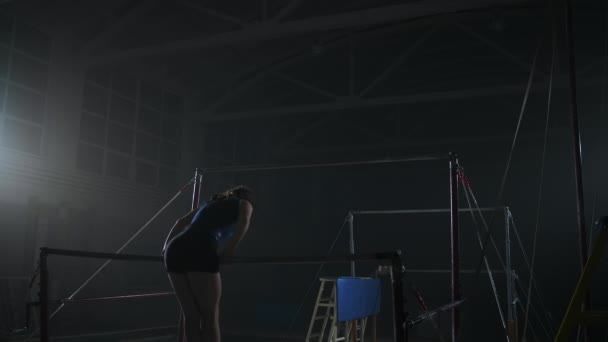 Träning på ojämna barer, ung idrottskvinna roterar på bar och hoppa, slow motion, konstnärlig gymnastik — Stockvideo