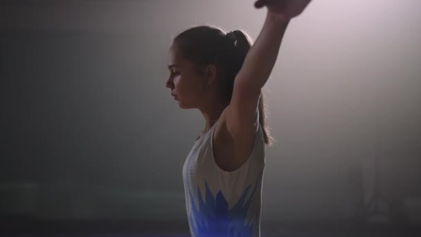 Дівчина-підліток тренує фліп в гімнастичному залі, виконує вправи на підлозі, готується до змагань — стокове відео