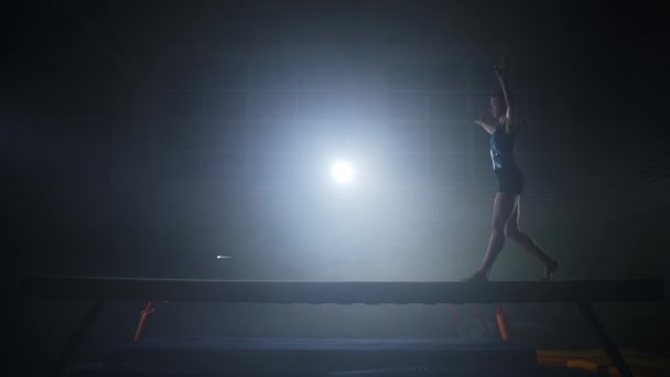 Adolescente vrouwelijke atleet presteert op balansbalk, training in sport school en de voorbereiding op de wedstrijd — Stockvideo