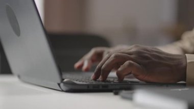 Modern dizüstü bilgisayarın klavyesinde çalışan Afro-Amerikan bir adamın elleri, yakın çekim görüntüsü, adam çalışıyor, mesaj gönderiyor.