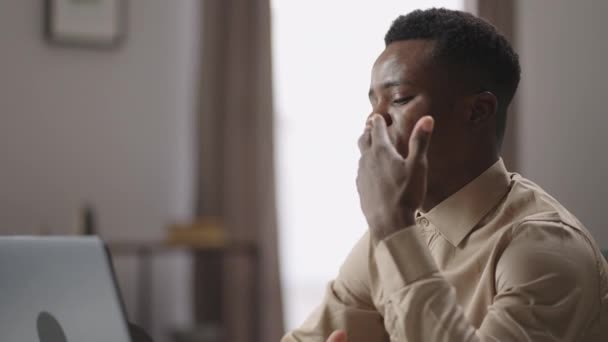 junger afroamerikanischer Kerl spricht mit Freunden per Videochat am Laptop, erzählt Geschichte und gestikuliert, Porträt eines schwarzen Mannes