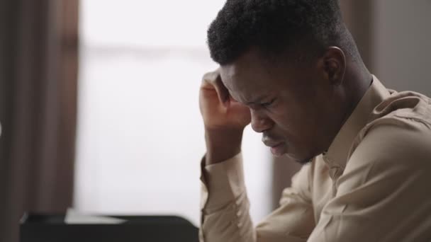 Estudiante negro hombre cansado o alumno está viendo en la pantalla de la computadora portátil en la habitación, el pensamiento y el sufrimiento, no entiende, difícil de la educación a distancia — Vídeos de Stock