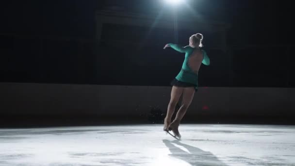 年轻女子花样滑冰选手正在溜冰场上双跳，在比赛前进行训练和热身 — 图库视频影像