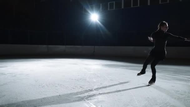 Молода талановита фігуристка катається на ковзанах, виконує кроки і обертається, тренується перед змаганням — стокове відео