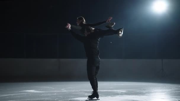 Фігурне катання на ковзанах, спортивна пара виконує елемент пара ковзанів, чоловік тримає свою партнерку на плечі — стокове відео
