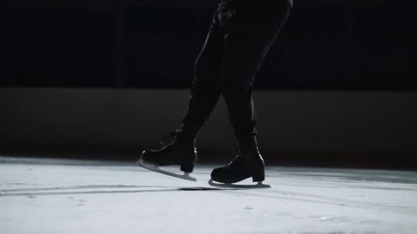 male figure skater is training or performing program on competition, closeup view on feet shod skates