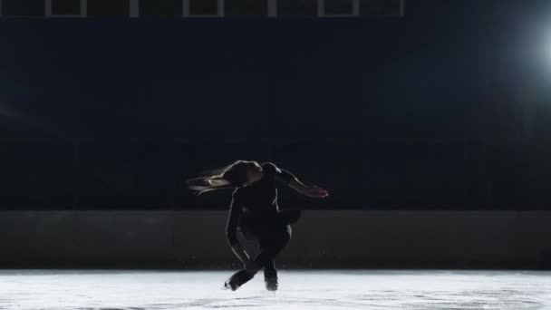 Młody utalentowana kobieta łyżwiarka figurowa jest trening na lodowisku, przędzenia na jednej nodze, profesjonalny sportowiec — Wideo stockowe