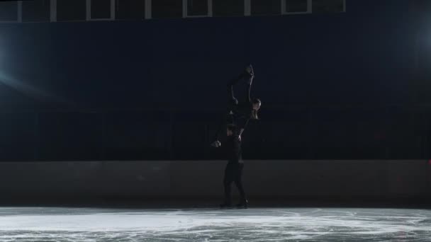 Elevador de patinação artística, par de patinadores estão patinando na pista de gelo, o homem está segurando mulher no ombro, câmera lenta de treinamento profissional — Vídeo de Stock
