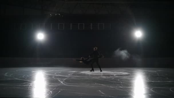 Два фігуристи катаються на ковзанах вночі, спортивна пара тренується на порожній арені, повільний рух, майбутні чемпіони — стокове відео