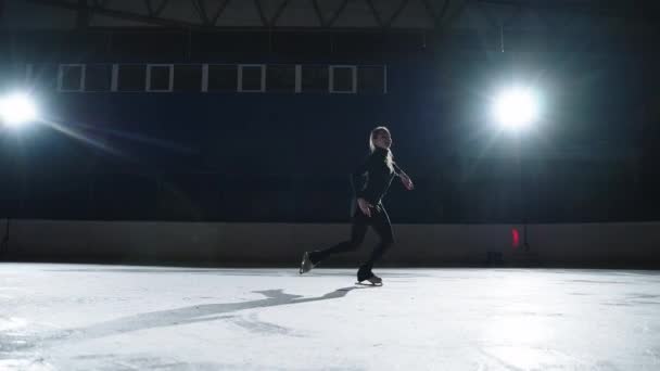 Zierliche Eiskunstläuferin führt Elemente auf der Eisbahn vor, Training der Profisportlerin vor dem Wettkampf — Stockvideo