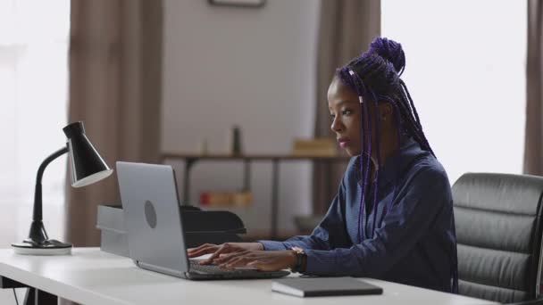 Giovane donna d'affari nera sta lavorando con il computer portatile in ufficio moderno, afro-americano signora sta comunicando via chat — Video Stock